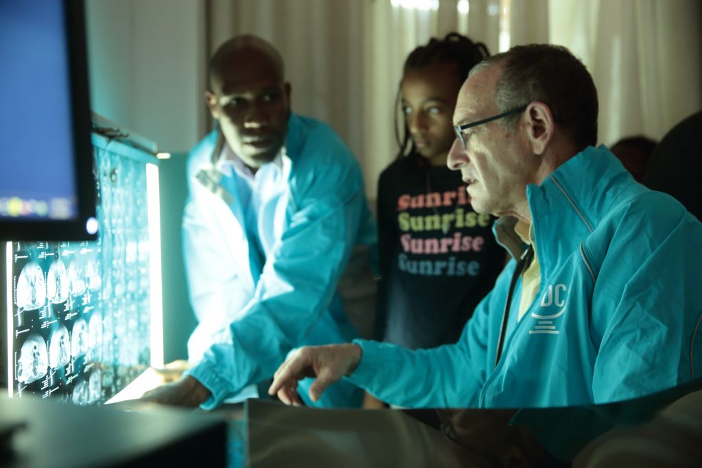 Dr. Rick Hodes looks at X-rays with a patient and colleague.