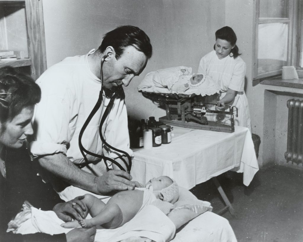 Doctors and nurses tend to newborns at one of the well-baby clinics set up and staffed by JDC medical personnel in the DP camps as survivors began to rebuild their lives, 1948.