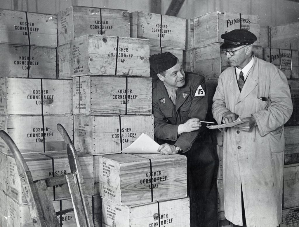 Inspecting supplies destined for Jews living in the DP camps at a JDC warehouse in Bremen, Germany, 1946.