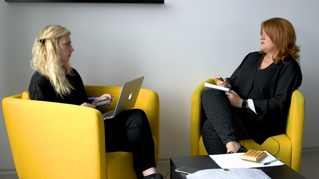 Julia sits with a colleague, discussing work.