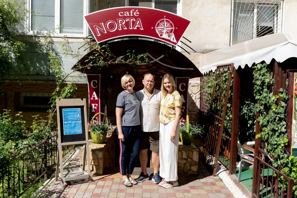 Katya and her parents stand in front of their restaurant, Norta.