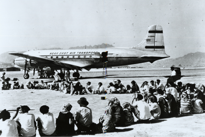 Yemenite Jews sitting on the tarmac in Yemen, waiting for JDC to airlift them to Israel during Operation Magic Carpet.