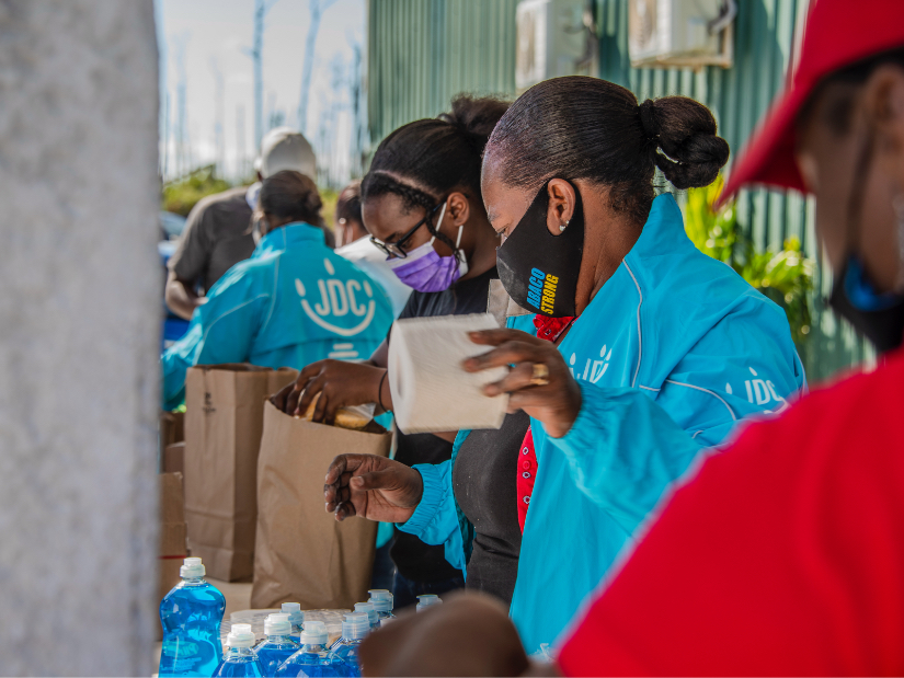 A JDC humanitarian aid workers in the Bahamas dispensing toilet paper and dish soap to victims of Hurricane Matthew.