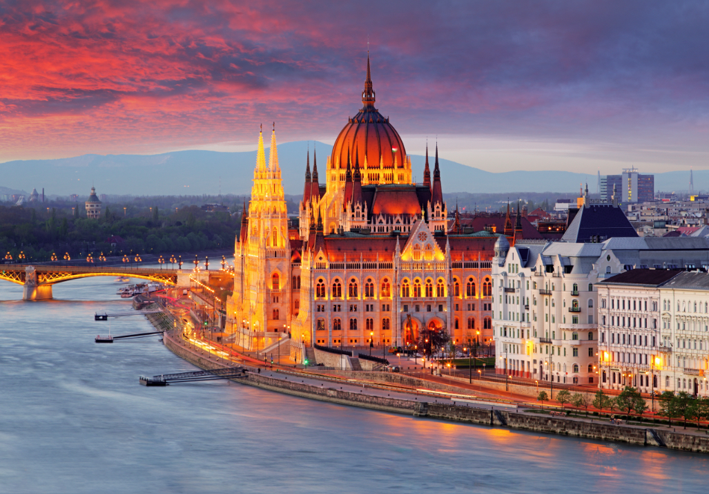 The Hungarian Parliament Building (Parliament of Budapest) in Budapest, Hungary, at dusk, next to the Danube River.
