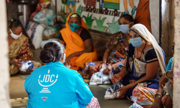 A JDC volunteer meets with a group of women.